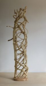 A tall free standing, handcrafted wooden sculpture. Branches weave in and out giving many focal points of interest.